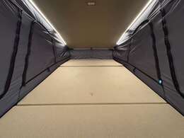 ポップアップルーフ内部。大人がゆったり横になれる190×100cmのルーフベッド。天井のフチには暖色LED照明がございます。