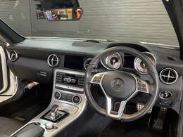 SLK200のコクピットは、低い着座位置とドライバーを包み込むような造形が特長です。操作系が手元に収まり、視線移動も最小限。スポーツカーらしい一体感と快適性を両立した設計です。