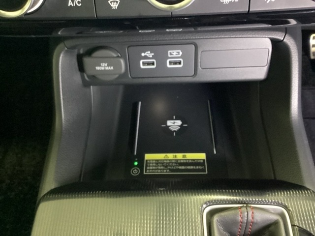 センターコンソールにはワイヤレス充電器を装備してます。Qi（チー）規格対応のスマートフォンなどを置くだけでワイヤレスで充電可能です。またスマートフォンの充電可能なUSB端子なども別途装備しています。