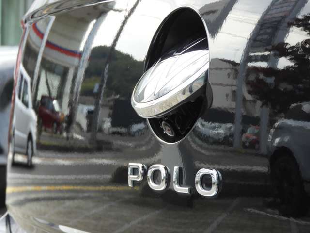 【バックカメラ（エンブレムタイプ）】　リアの「VW」エンブレムの内部にバックカメラを装備。バックギアに切り替えるとリアのエンブエムが開いてバックカメラが作動、雨の日でも鮮明な画像を確認できます。