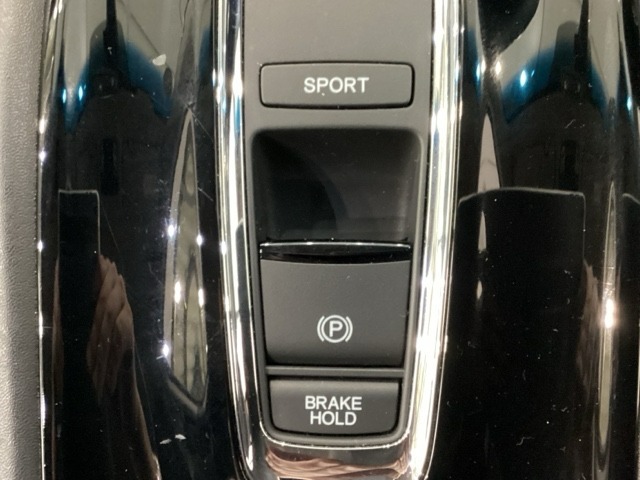 セレクトレバーの下に電子制御パーキングブレーキがあります。スイッチひとつで、停車した地点の傾斜などをシステムが検知・判断してブレーキ力を自動的に最適制御し、しっかり停車できるパーキングシステムです。