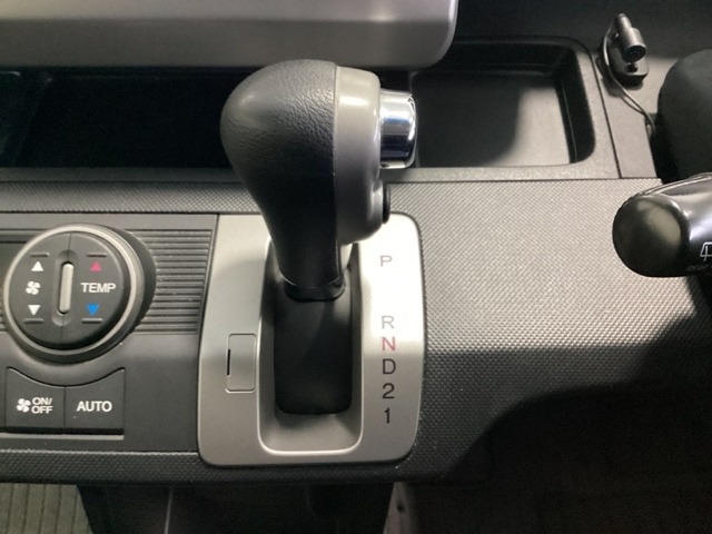 5速AT車のセレクトレバーです。低速から高速までスムーズな走りを実現するとともに、エンジン効率のよい領域を維持することで燃費にも貢献します。