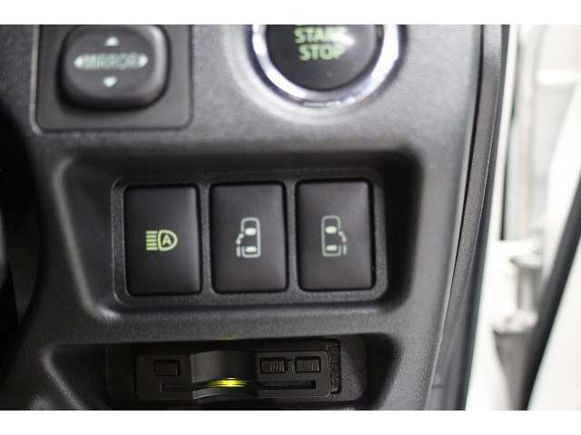 両側電動スライドドア装備で画像のスイッチにより運転席からもドアの開閉が可能です。左側のスイッチはオートマッチクハイビームのスイッチです。明るさを判定し、自動的にハイビームとロービームを切り替えます。