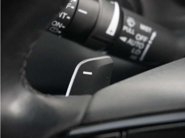 【減速セレクター】ステアリングホイールの左右に取り付けられた2つのパドルスイッチで減速の強さを調整。 左側の「-」を操作すると減速を強く、右側の「＋」を操作すると減速を弱くすることができます。