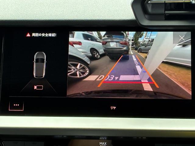 【リヤビューカメラ】車両後方の映像を映し出し、舵角に基づいて計算された経路を画面に示して駐車操作をサポートします。