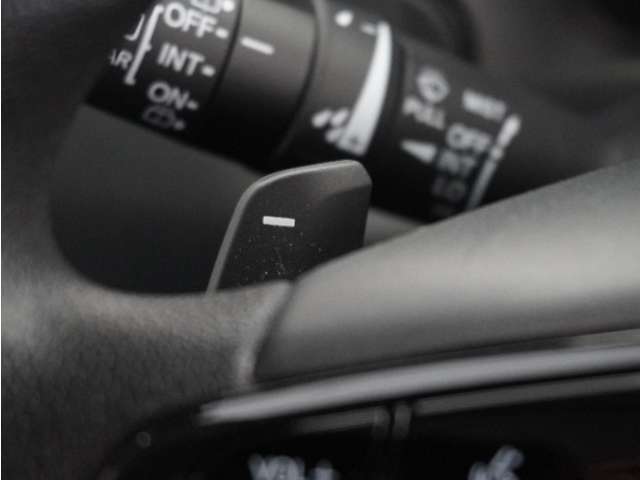 減速セレクターは、ステアリングホイールの左右に取り付けられた2つのパドルスイッチで減速の強さを調整。 左側の「-」を操作すると減速を強く、右側の「＋」を操作すると減速を弱くすることができます。