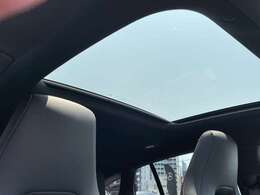 【パノラミックライディングルーフ】紫外線を効果的に遮るUVカットガラスを採用し、ウインドデフレクターも装備しています。ワンタッチ開閉機能、挟み込み防止装置も備わります。後部座席のガラスは開閉しません。