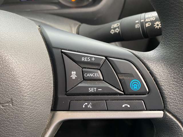 【プロパイロット】高速道路でアクセル、ブレーキ、ステアリング操作をクルマがサポート。高速走行におけるドライバーの負担を軽減します。その下には、携帯電話用ハンズフリースイッチが並びます。