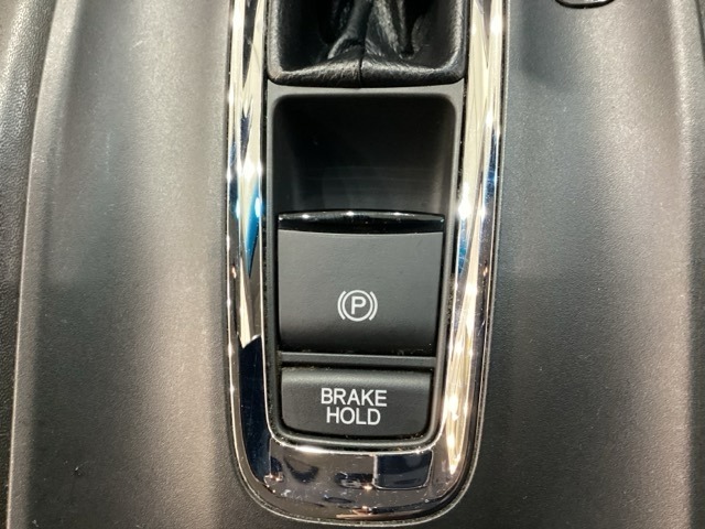 セレクトレバーの下に電子制御パーキングブレーキがあります。スイッチひとつで、停車した地点の傾斜などをシステムが検知・判断してブレーキ力を自動的に最適制御し、しっかり停車できるパーキングシステムです。