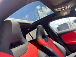 【パノラミックライディングルーフ】紫外線を効果的に遮るUVカットガラスを採用し、ウインドデフレクターも装備しています。ワンタッチ開閉機能、挟み込み防止装置も備わります。後部座席のガラスは開閉しません。