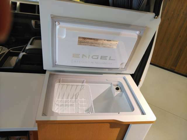 右側には40L冷蔵庫(ENGEL ビルトインタイプ)が設置されていました。ミドルルーフではバンだけに設定の両側スライドドア、外から冷蔵庫へアプローチもOK。蓋を閉じれば大きなカウンターテーブルとして利用できます。