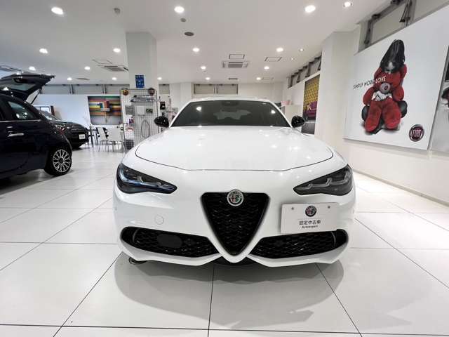 盾型グリルとアルファロメオエンブレムが真ん中にあって日本車では珍しいナンバープレートが端にあります
