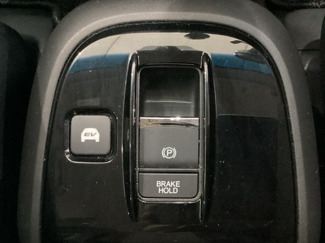 セレクトレバーの下に電子制御パーキングブレーキがあります。スイッチひとつで、停車した地点の傾斜などをシステムが検知・判断してブレーキ力を自動的に最適制御し、しっかり停車できるパーキングシステムです。