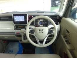 ベージュを基調としたデザインで、室内は広々と感じられます。ナビやエアコンなど必要な装備もしっかりとそろっています。エアコンの吹き出し口にさりげない赤のアクセントが入って、室内を引き締めています。