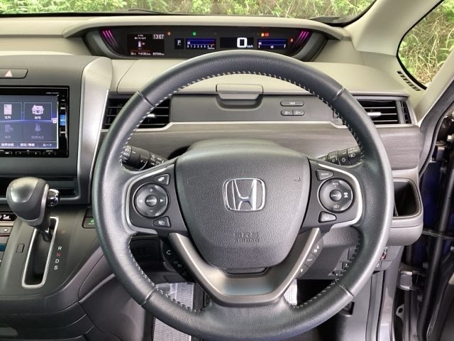 本革ハンドルの右側にあるボタンが高速クルーズコントロールです。アクセルペダルを踏まずに設定速度をキープ。高速道路でのドライブがラクに。また、左にオーディオリモコンスイッチがあります。