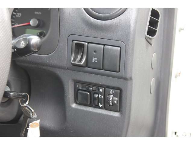 ハンドルの右側にはフォグランプスイッチ、電動格納ミラースイッチ、ヘッドライトレベライザースイッチ、コインケースがございます。