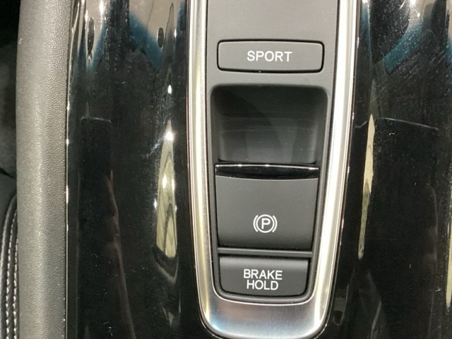 セレクトレバーの下に電子制御パーキングブレーキがあります。スイッチひとつで、停車した地点の傾斜などをシステムが検知・判断してブレーキ力を自動的に最適制御し、しっかり停車できるパーキングシステムです。