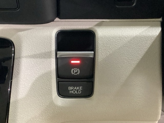 セレクトレバーの右に電子制御パーキングブレーキがあります。スイッチひとつで、停車した地点の傾斜などをシステムが検知・判断してブレーキ力を自動的に最適制御し、しっかり停車できるパーキングシステムです。