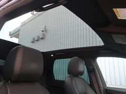 【パノラミックルーフ】車内に気持ちいい自然光が差し込み、頭上に広がる風景をお楽しみいただけます。快適な車内温度を維持し日差しから乗員とインテリアを守るダークカラーのガラス。電動ブラインド付き！