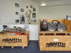 歴代のアバルトのパネルやヒストリックアバルトのパーツを展示したガレージのようなショールーム