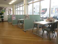 明るく清潔感のある店内。納得のいく車選びをお手伝いします！一番奥のテーブルからはサービス工場の様子を見ることもできます。