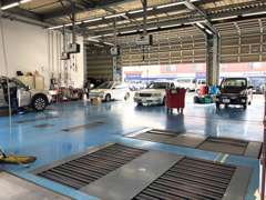 ブルーの床が爽やかな整備工場は、最新のシステムを導入し、お客様の車をメンテナンスいたします。