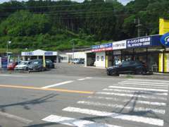 国道9号線沿い、青い看板が目印のお店です。国産車・輸入車・新車・中古車まで取り揃えております。
