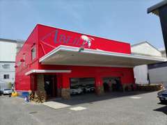 赤い建物にブルーカラー『ABEILLE（アベイユ）』のロゴ！白い大きなハチがお客様をお出迎え致します！