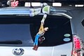 「あ、落ちそう」 クルマから「人形ぶらぶら」問題ない？ 「名シーン再現、胸熱っ！」だけど… 街中で見かける斬新カスタムの注意点とは